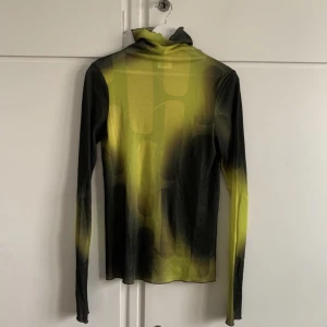 H&M Studio AW22 topp - Supersnygg topp från H&M Studio AW22. 100% lyocell. Använd en gång och är som ny (materiallappen dock bortklippt). Ser gul ut på bilden men drar åt grönt