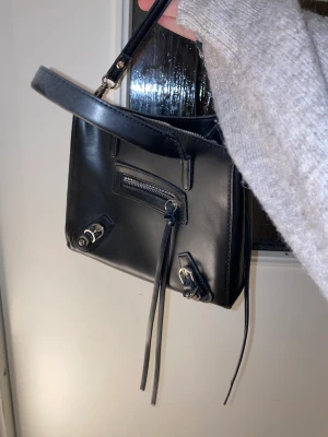 Axelremsväska  - Axelremsväska ifrån Nelly.  Köpt för 2 år sen och använd 3 gånger ungefär.  