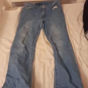 Blåa flared jeans med eld på baksidan från SHEIN storlek S
