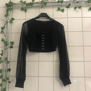 Topp🖤 - Kort topp med mesh armar och silvriga hyskor fram 