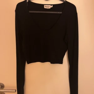 Tröja - Svart topp från NA-KD med lite delats vid bysten, ganska croppad.