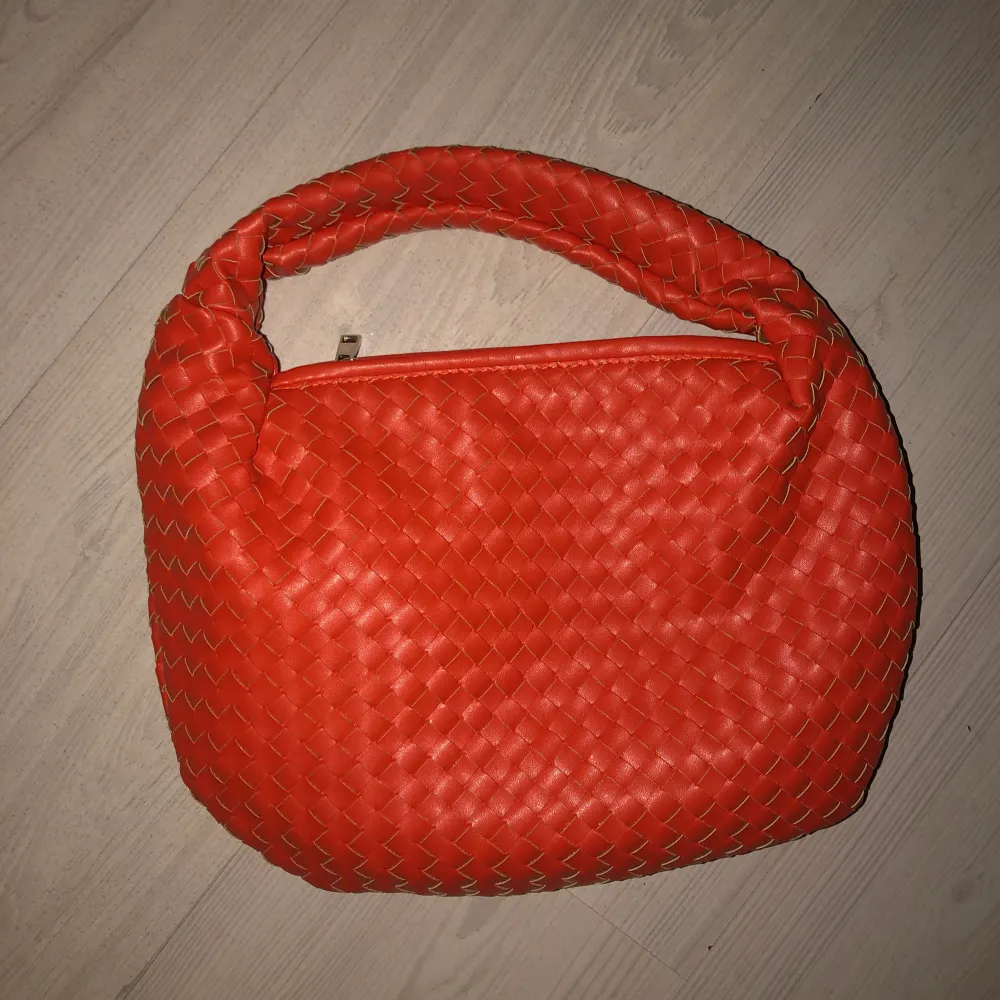 Säljer denna jätte fina vävda väskan från nakd som nästan är identisk med den omtalade bottega väskan! Jätte fin orange röd färg som livar upp en outfit jätte fint! Men använder den inte så mkt längre! . Väskor.