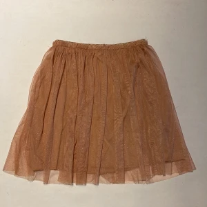 Rosa/guld tyll kjol - Super fin tyll kjol i rosa/guld detaljer.  Köparen står för frakten. Jag ansvarar inte för postens hantering. Jag visar bild på när jag skickar paketet. Vid fler intressen av objekt kan bud över begärt ingångspris läggas.