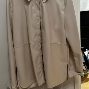 Fuskskin skjorta i beige  - Snygg skjorta i fuskskin. Knappt använd i super fint skick. 
