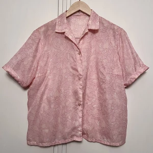Rosa kortärmad vintageskjorta  - Gullig rosa kortärmad skjorta köpt på Pop Stockholm. Något croppad passform. Etiketten säger att den är strl 48 men skulle säga att den mer passar en M/L.  Kan frakta eller mötas upp inom Stockholm! 80kr + frakt 🌸