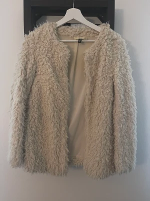 Lurvig jacka från H&M - Lurvig jacka/kofta från H&M. Använd två gånger. Två fickor och kan stängas med ”hakar”. Köparen betalar frakt