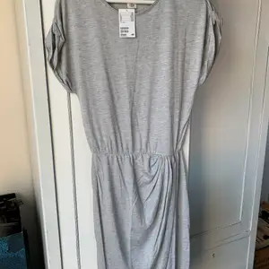 Grå klänning från H&M i storlek S. Oanvänd med lappen kvar
