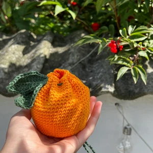 Handvirkad apelsinväska - En till liten väska som jag virkat själv, denna gången som apelsin! Den öppnas och stängs genom snörningen (som kan ses på bild). Kan bland annat användas för småpengar eller varför inte godisgömma💗 Hör gärna av dig vid frågor eller intresse!