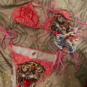 ed hardy bikini - Super snygg ed hardy bikini med sjuka detaljer på baken💋 aldrig använd! Toppen är i storlek L och underdelen är i storlek M, skulle dock säga att storlekarna är pytte lite mindre