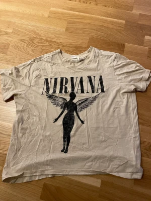 Snygg Nirvana t-shirt - Snygg beige graphic Nirvana t-shirt! Säljer då jag inte använder den längre, fortfarande i bra skick. Storlek L men passar som M/L!
