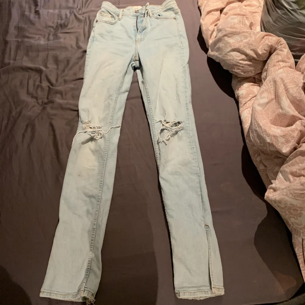 Vanliga blåa jeans med hål i och slits längst ner vid benet, ser ut som bootcut på. Jeans & Byxor.