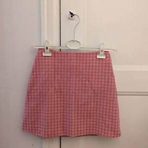 Hundtandsmönstrad kjol - Fin pennkjol från Monki i rosa och beige hundtandsmönster. Storlek XS.