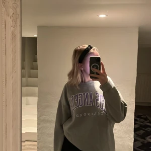 Sweatshirt  - Grå sweatshirt med lila tryck i storlek 36. Köp 2 tröjor och frakten ingår i priset. 