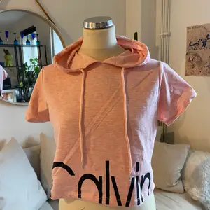 En rosa (fake!) Calvin Klein hoodie. Den är ganska kort croppad.  Strlk L men skulle säga att den inte är så himla stor 
