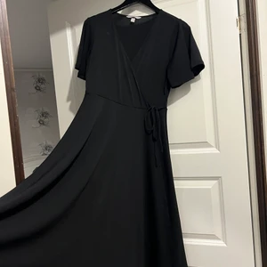Omlottklänning - Svart omlottklänning i storlek S. Jättefin klänning men som aldrig riktigt kommit till användning. 