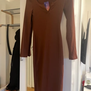 Knälång klänning oanvänd  - Jätte fin brun klänning med slits bak
