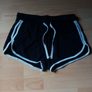 Svarta shorts i storlek S/158-164 - Ett par svarta shorts med vita sträck på sidorna och fickor. Använd en gång. 
