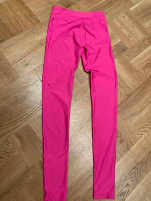 Under Armour träningstights xs - Ett par knallrosa träningstights från Under Armour stl xs. Compression. Använda men i fint skick