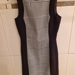 Formal dress - formal dress, unworn, falls above the knee, and is tight.