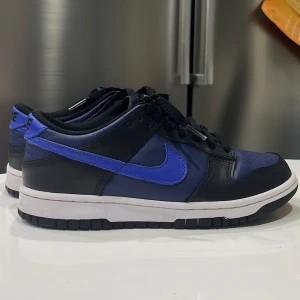 Nike Dunk Low Black Blue (GS) - Ett par dunks som jag köpte i somras! de har tyvärr inte kommit till så mycket användning eftersom jag köpte en storlek för liten! använt de kanske 4-5 gånger, lite creased men ska lösa de! mer info får ni om ni skriver till mig om ni har några frågor!