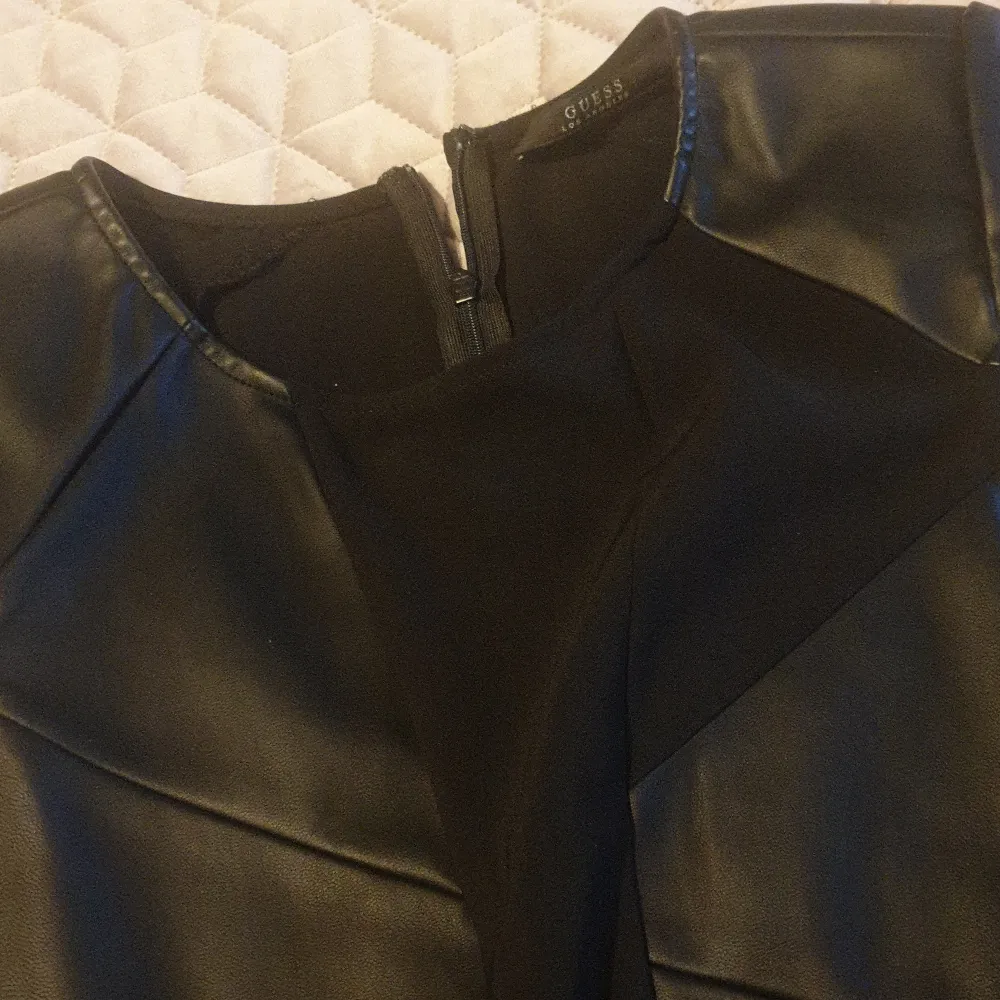 En svart klänning från Guess som har använts 2 gånger. Mixed material i läder imitation och stretch.Nypris 1400. Jag säljer den för att jag gått upp i vikt och har inte kunnat använda den på flera år.. Klänningar.