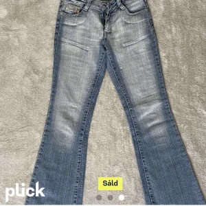 Lågmidjade jeans  - Jättesnygga lågmidjade jeans med fint tryck på bakfickorna. Köpt på plick därav bilderna från förra ägaren. Säljer då dem var för små. Midjemått: 74 cm. Annars jättefina och nya. Passar på längden runt 164-167. Säljer dem för 500 inkl frakt! Skriv för mer