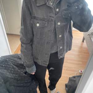 En svart/grå jeans jacka ifrån Gina tricot 