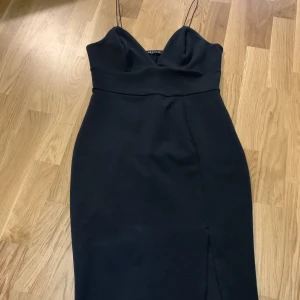 Svart tight klänning - Tight ganska kort klänning med en slits framtill på låret. Storlek M. Skulle säga stor S. Mycket fin. Säljes pga slitsen blev lite för öppen på mig som har ganska stor rumpa och lår.