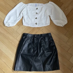Kläder - En vit långärmad kropp topp tillsammans med en svart skinkjol. Använd vid få tillfällen.  Kjol: strl s/m 59kr Tröja: strl l 49kr  