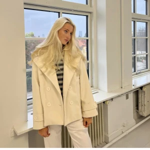 Design by si - Gina coat - Storlek xs/s Använt en gång, säljer då jag hellre velat ha en annan färg, men nu är det för sent för att skicka tillbaka.  Köpte den för 800kr inclusive frakt.  Säljer för 550 + frakt eller för 600 kr vid upphämtning  Obs, jackan är offwhite/beige.