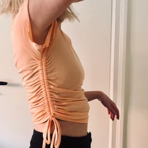 Topp med dragsko i sidan strl S - Topp med dragsko i sidan. Jättefin och somrig pastellfärg! Strl S. Ingen lapp i men kan tänka mig att den är ifrån Gina tricot. Mjuk och skön i materialet!