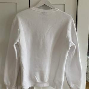 En vit sweatshirt köpt på killavdelningen på hm