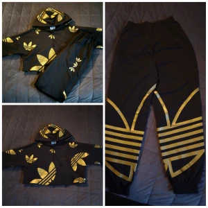 Adidas guld dress  - Adidas guld sett. Olika storlekar på byxor och tröja. Storleken på byxorna är 34 och tröjan storlek 32. Kläderna är endast använda I danstävling. Så absolut nyskick. 