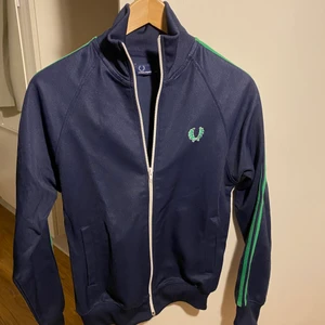 Fred Perry, mörkblå träningsjacka - Fred Perry träningsjacka, mörkblå och grön. I gott skick. Storlek S i herrstorlek. 
