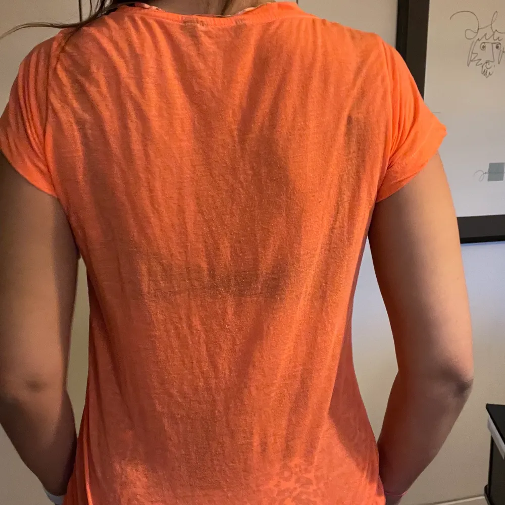 En lite genomskinlig snygg orange t-shirt, från Lindex! Den har ett super litet hål på framsidan(syns knappt när man har på sig tröjan) stl xs men funkar bra som medium eller större till å med!. T-shirts.