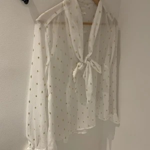 Knytblus - Vacker knytblus. Genomskinlig med glittrande detaljer. Helt oanvänd! 