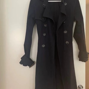 Mint&Berry trenchcoat - En marinblå trenchcoat från mint&berry  en av fickorna har ett litet hål men det går enkelt att laga i övrigt väldigt fint skick  Storlek 36 
