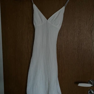 Sommarklänning - En super fin sommarklänning med tunna band, en liten slits och djup rygg med korsband från HM. St.XXS-XS, aldrig använt. Klänningen är kort vilket det inte ser ut som på bilden