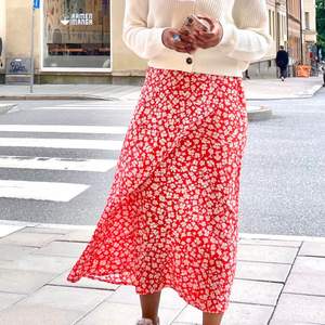 En röd och vit blommig kjol, perfekt för sommaren, lätt och skön material så att man slipper svetta på sommaren :). 