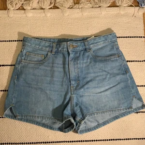 Jeansshorts - Shorts från Monki, storlek 28 (motsvarar S). Bra passform o material, mellanblå färg. Använt de ett flertal ggr men fortfarande i bra skick!