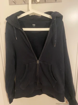 Blå ziphoodie - En mörkblå zip hoodie i fint skick. Den är ifrån uniqlo och är använd men fortfarande i ett fullt fungerande skick. 