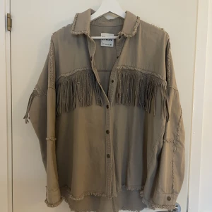 Beige skjortjacka från Zara - Beige skjortjacka med fransar och nitar från Zara. Storlek S. Inget fel på jackan.
