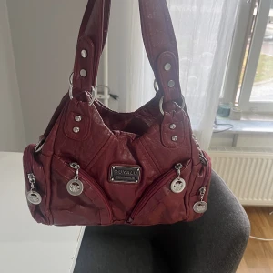 Röd väska - Den skitsnygga röda vintage väska, passar till allt! Superbra skick då den bara är använd en gång, det lämgre bandet ingår även, så den passar att ha på flera sätt! Supersnygg färg och väskan har flera fack. Säljs gör 450, (kan eventuellt diskuteras)❤️