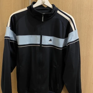 Adidas zip  - Blå/vit adidas zip köpt secondhand, använd fåtal gånger. 