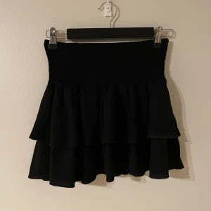 Svart minikjol / kort volangkjol  - Ganska kort. Har resår i midjan så passar de flesta. Supersöt