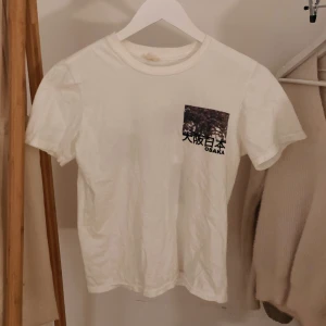 T-shirt - Stilren t-shirt från Urban Outfitters med tryck på ryggen. Använd en gång. Stl XS, passar även S 