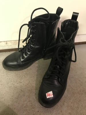 Svarta kängor  - Snygg svart känga med snören och dragkedja på sidan. Enkla att ta av och på. Låg klack. Bekväma storlek 38.