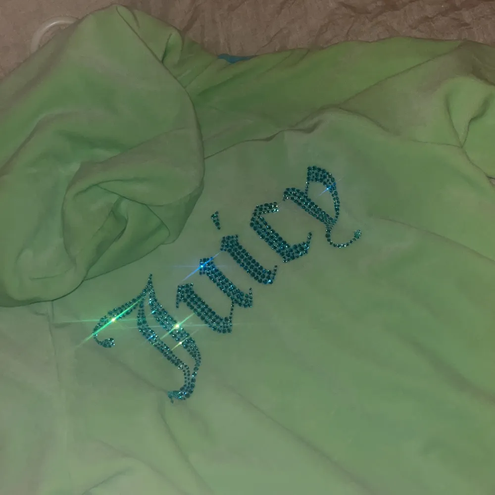En tröja från juice couture i storlek M aldrig använd råka ta av pris lappen säljer för ett bra pris den är i en jätte fin färg grön med blå linjer på sidan och med en text jucy på ryggen i blått  med kristaller . Tröjor & Koftor.
