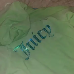 En tröja från juice couture i storlek M aldrig använd råka ta av pris lappen säljer för ett bra pris den är i en jätte fin färg grön med blå linjer på sidan och med en text jucy på ryggen i blått  med kristaller 