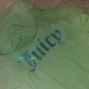 Juicy couture  - En tröja från juice couture i storlek M aldrig använd råka ta av pris lappen säljer för ett bra pris den är i en jätte fin färg grön med blå linjer på sidan och med en text jucy på ryggen i blått  med kristaller 